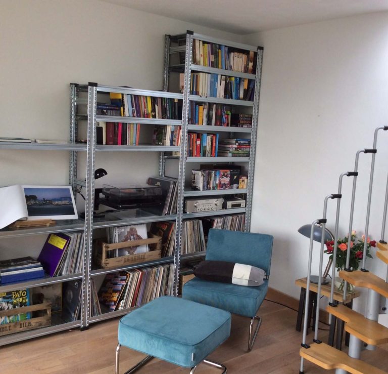 Stellingkast in de woonkamer gevuld met boeken, platenspeler, vinylplaten en accessoires.