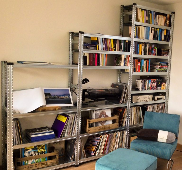 Stellingkast in de woonkamer gevuld met boeken, platenspeler, vinylplaten en accessoires.